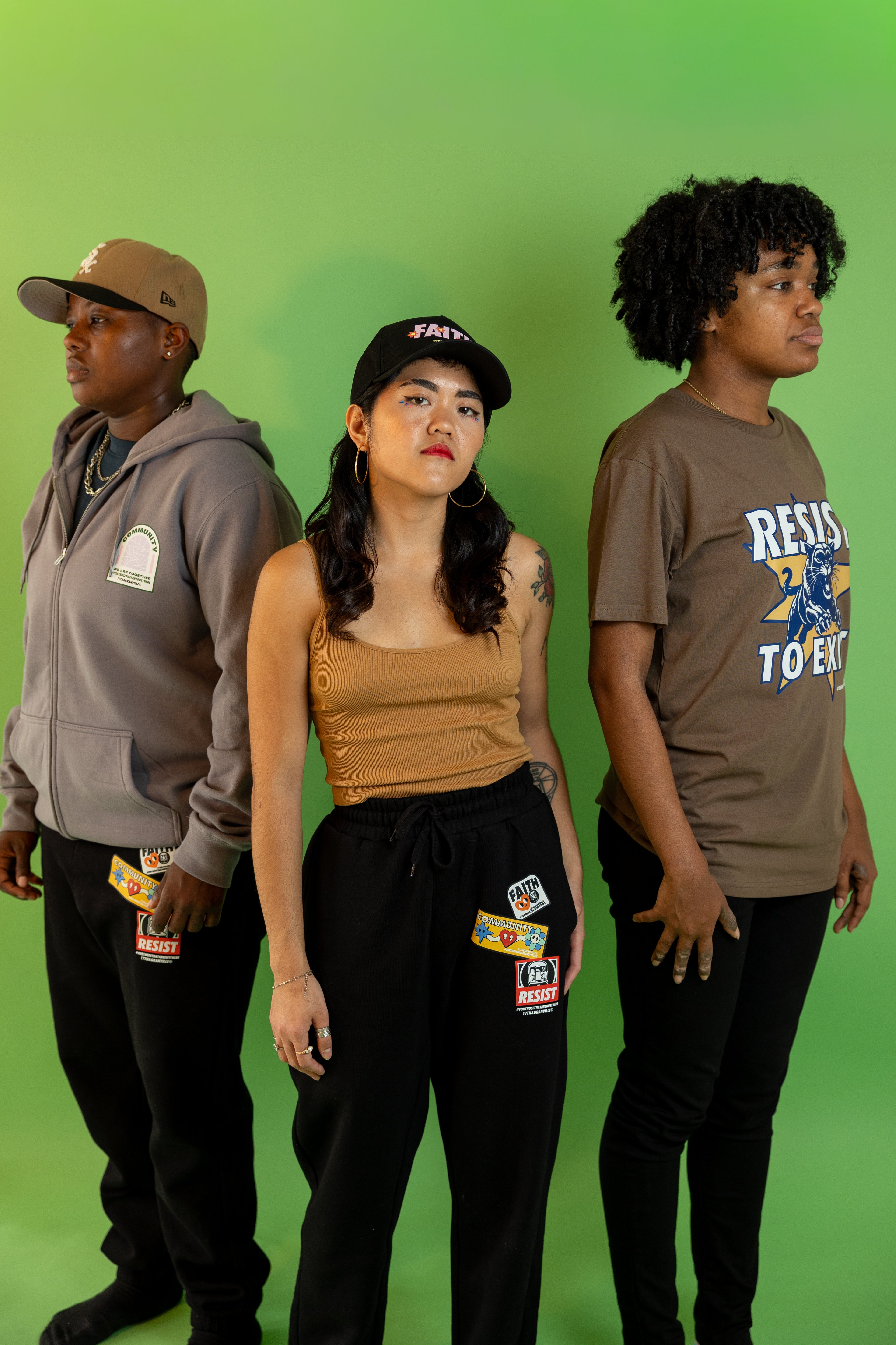 Three people standing against a green background, wearing pieces from 17th & Granville's Resist Collection