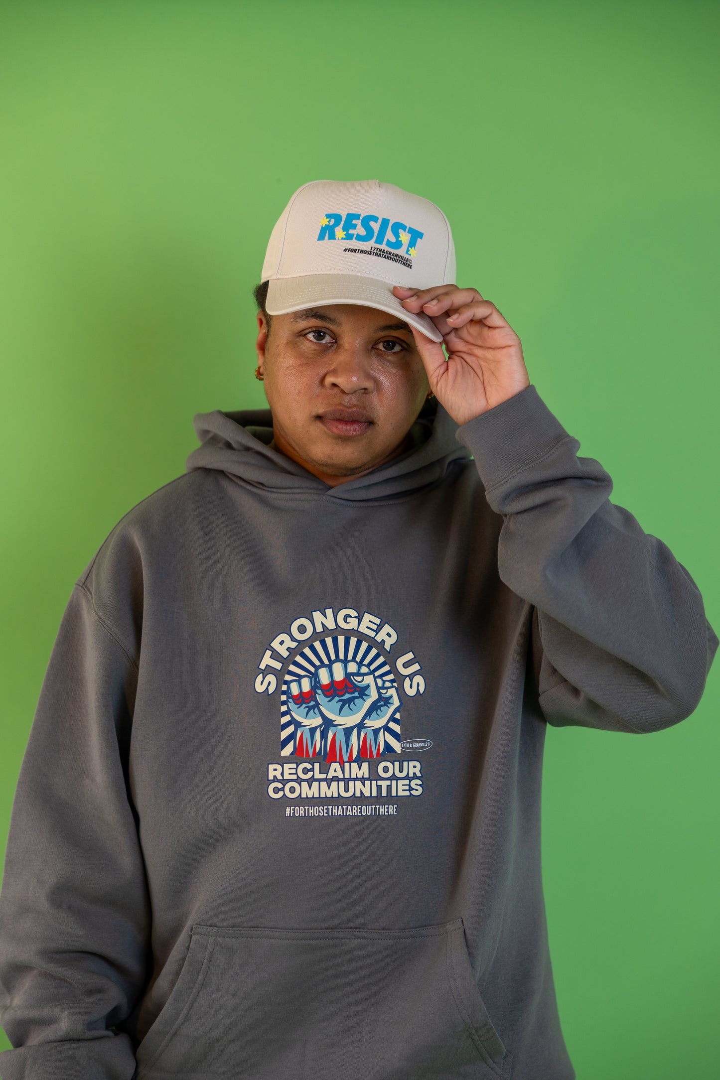 Donny, founder of 17th and Granville, wearing the Reclaim Our Communities hoodie and Resist hat while looking forward.