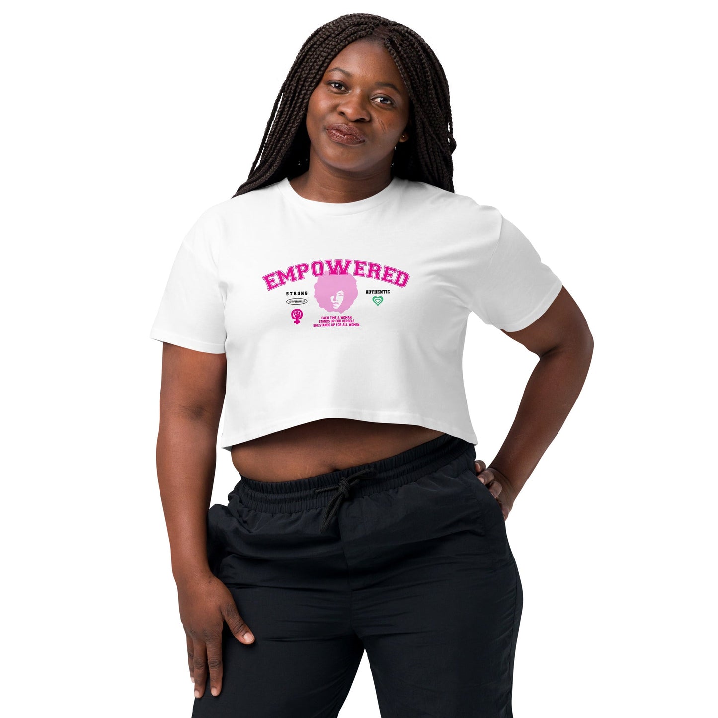 A woman with long, braided hair confidently wears the Empowered Crop Top crafted from premium fabric paired with black pants. She has a slight smile as she poses against a plain white background, highlighting the quality of this piece from 17th & Granville, a black-owned company.