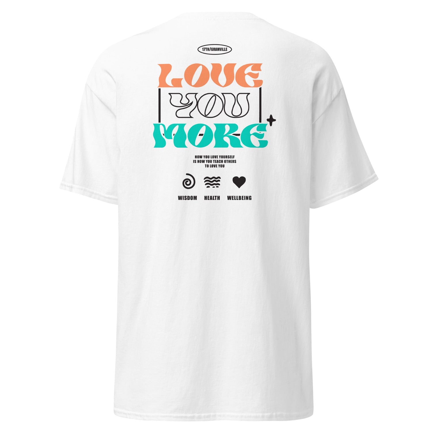 A white T-shirt featuring the text Love You More in large, colorful letters. Below are icons labeled Wisdom, Health, and Wellbeing, with a small motivational message.