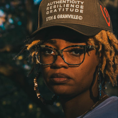 Two people standing outdoors with a blurred natural background