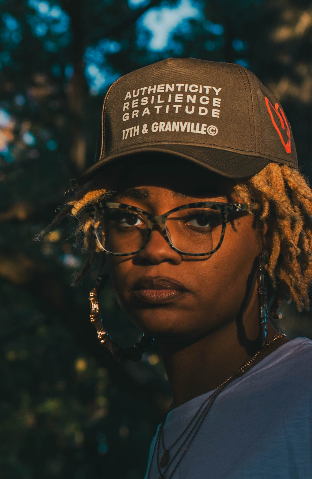 Two people standing outdoors with a blurred natural background