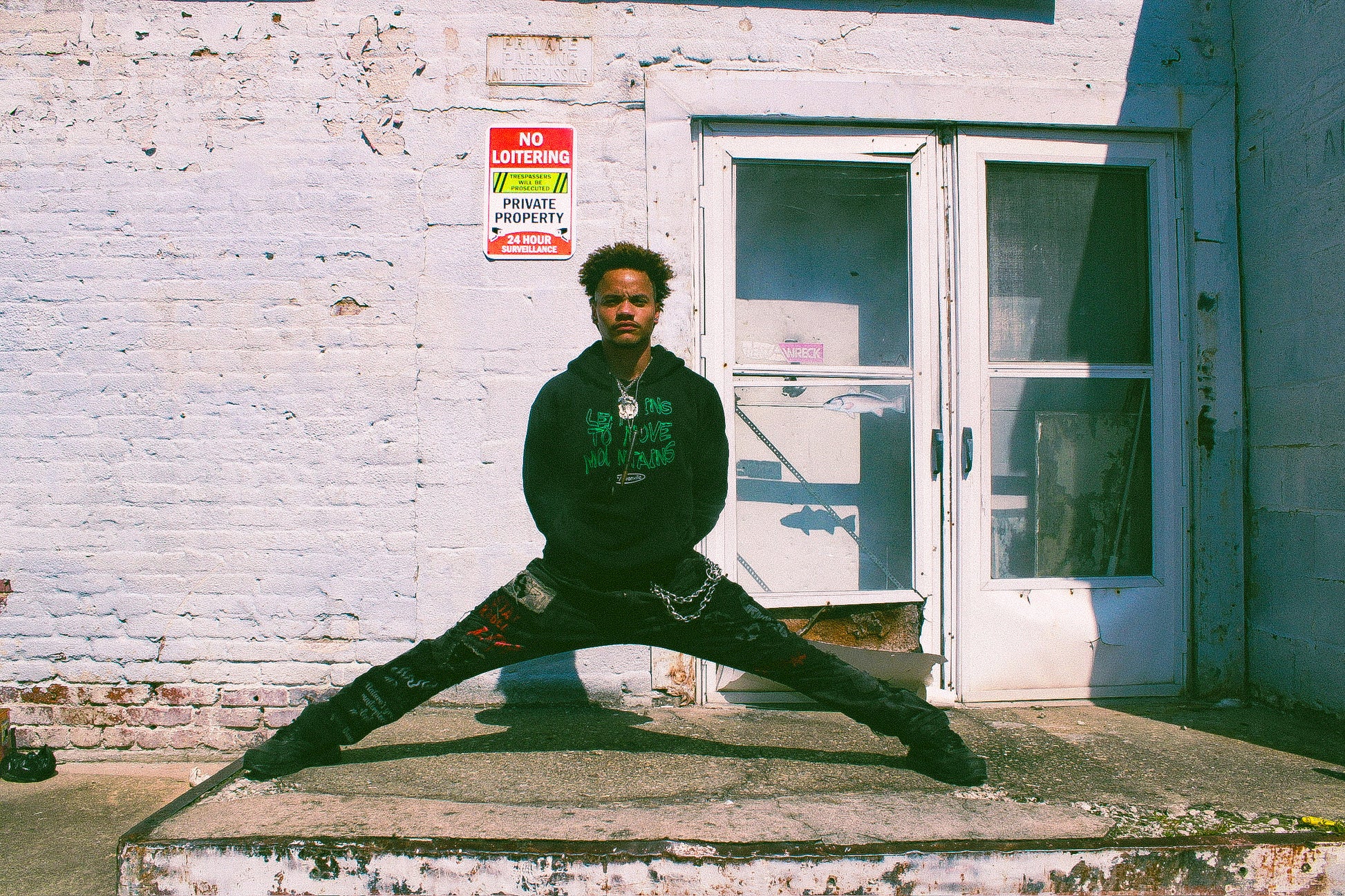 BIPOC model wearing black organic Eintou Collection hoodie with embroidered design, showcasing empowered expression. Part of 17th & Granville's fashion activism collaboration supporting BIPOC and LGBTQ+ communities.