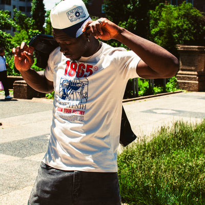 Model wearing the Juneteenth Know Your History tee and Juneteenth snapback in a different pose.