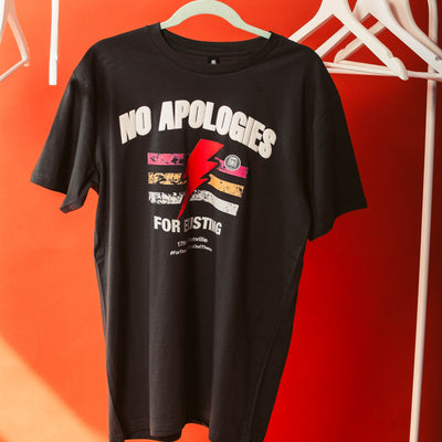 17th & Granville t-shirt with 'No Apologies' text and graphic on a hanger against an orange wall.