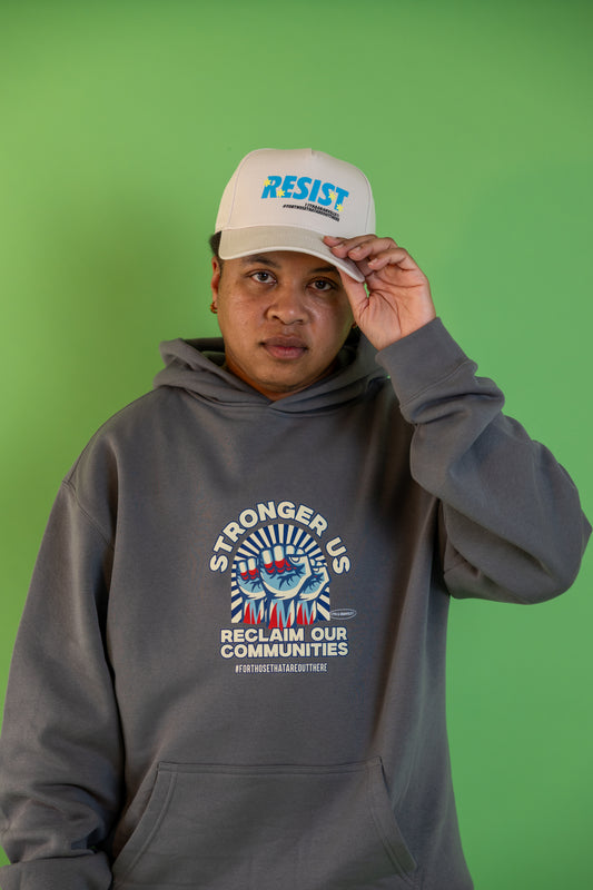 Donny, founder of 17th and Granville, wearing the Reclaim Our Communities hoodie and Resist hat while looking forward.